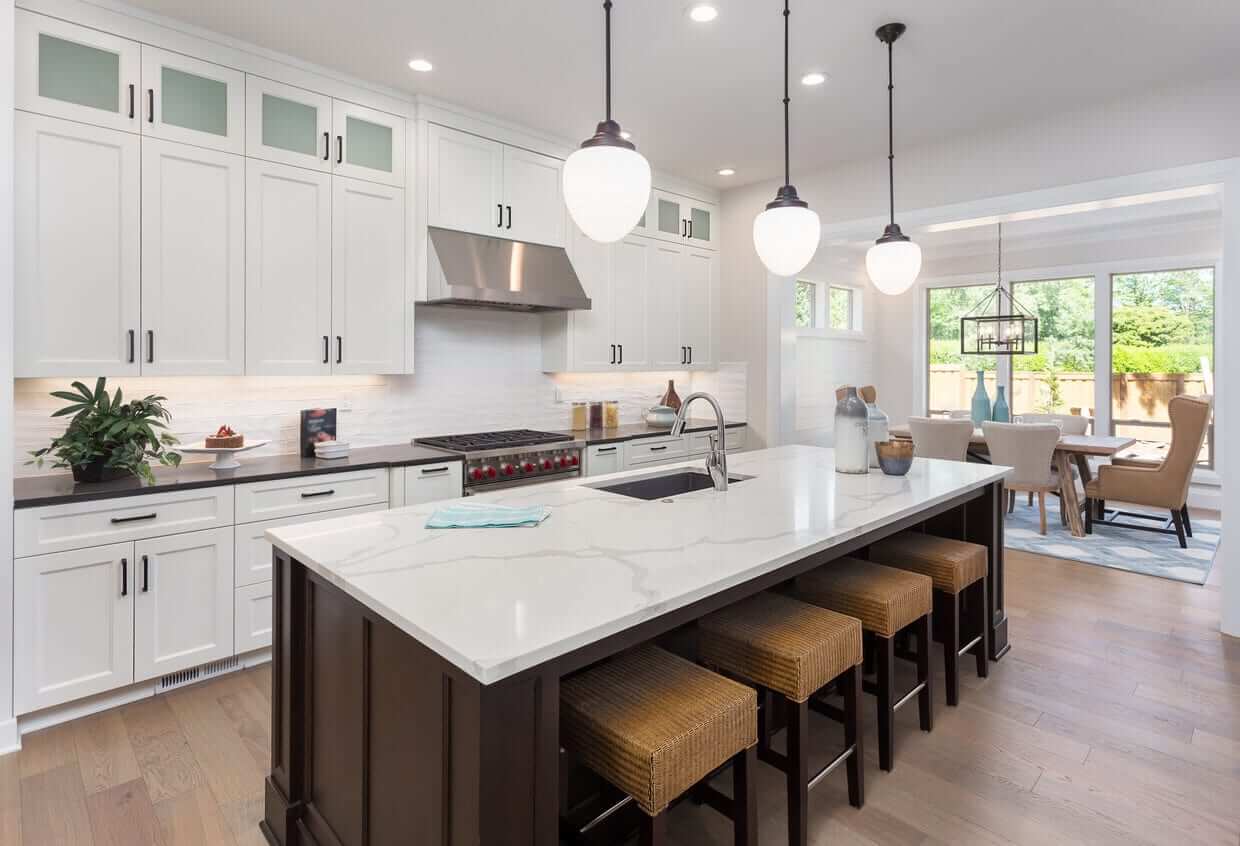 Contemporary kitchen with white cabinetry, quartz benchtops, a large island with seating and pendant lighting