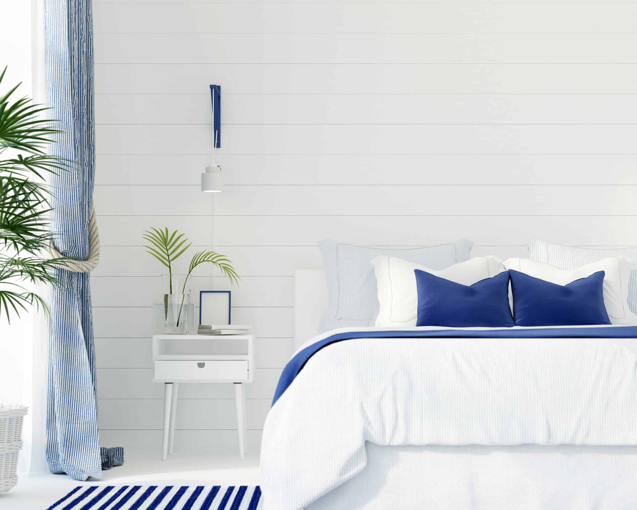 Light-coloured bedroom with white walls and blue accents.
