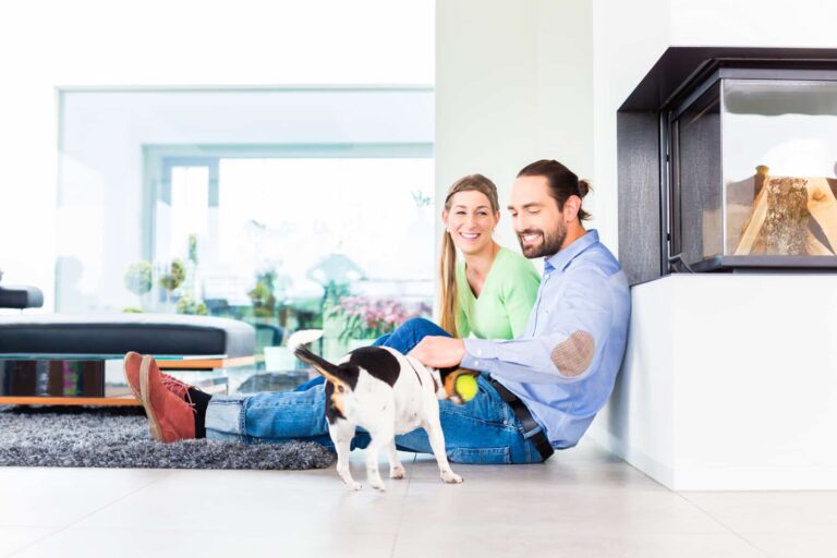 A couple playing with their dog on the floor