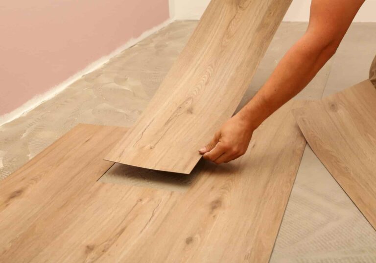 Close up of someone installing vinyl plank flooring