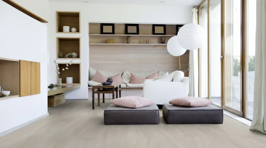 Contemporary living room featuring light wood sheet vinyl flooring, built-in shelving with decorative items, striped cushioned seating, dark ottoman with red striped pillows, white pendant lamp, an...
