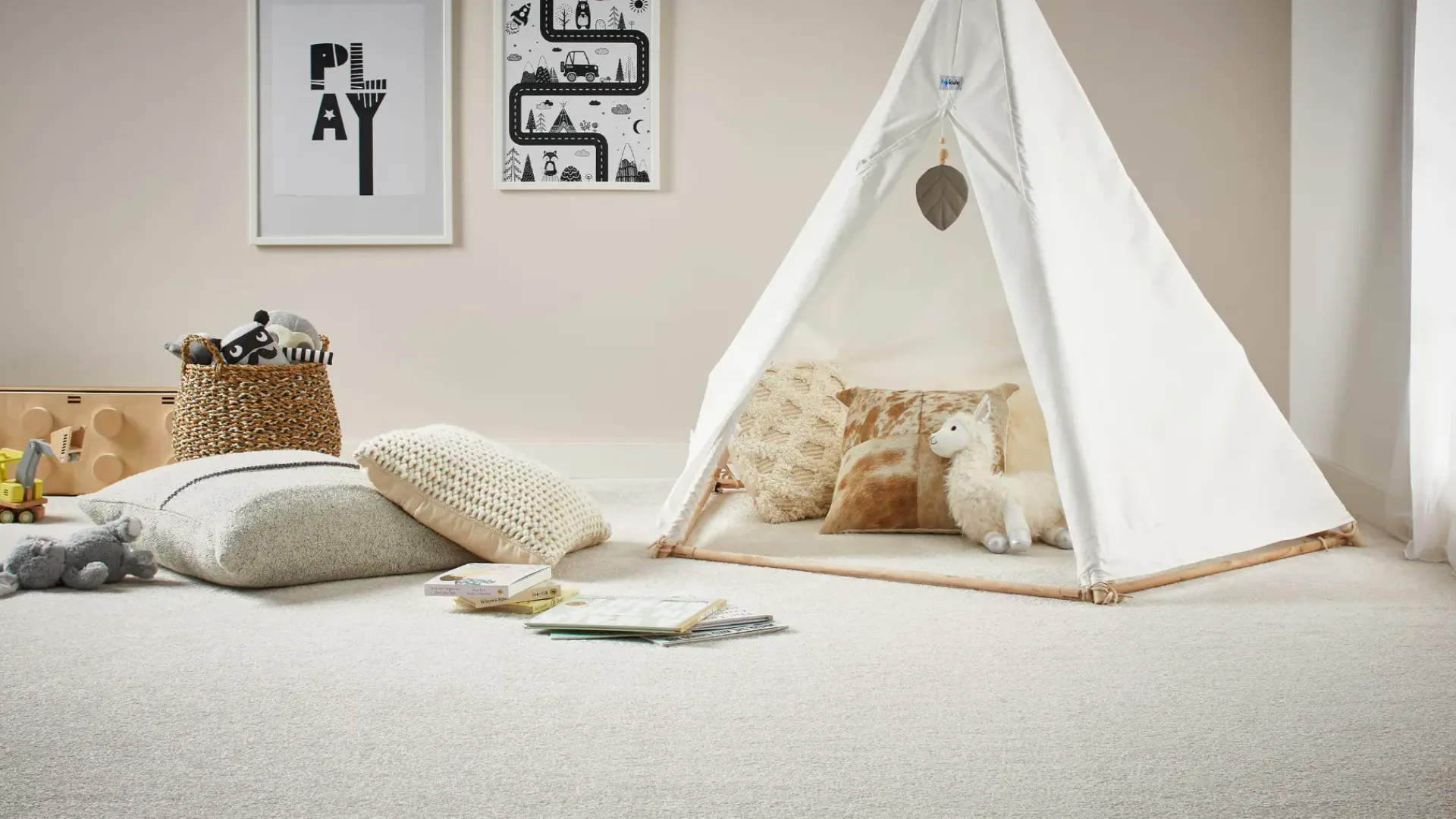 Child's bedroom featuring a white canvas teepee tent with wooden frame, containing patterned pillows and stuffed animals, positioned on soft triexta carpet next to gray cushions, books, and a woven...
